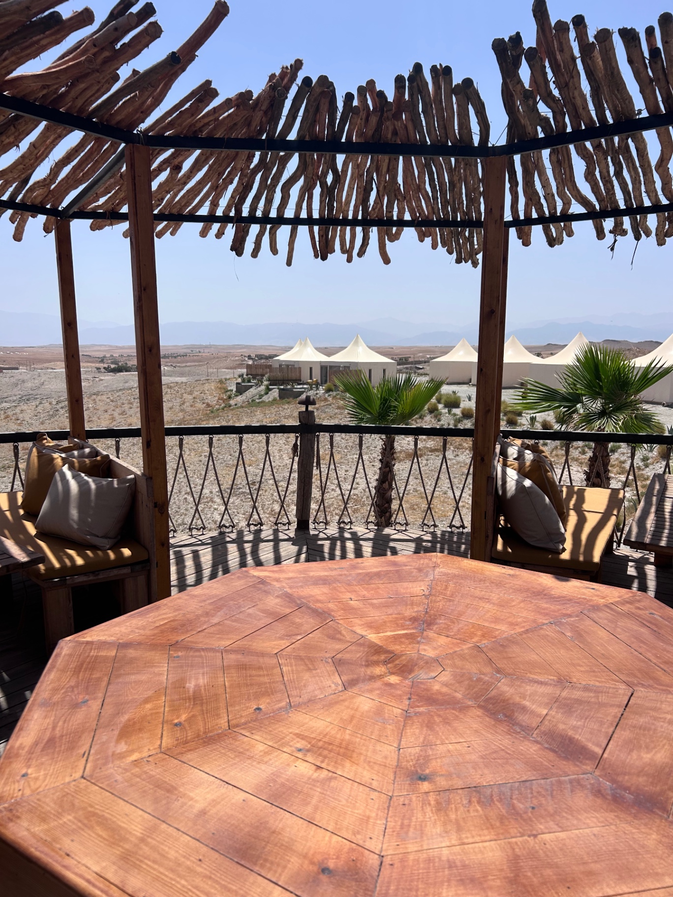 Terrasse en bois d'un camp à Agafay face aux tentes blanches